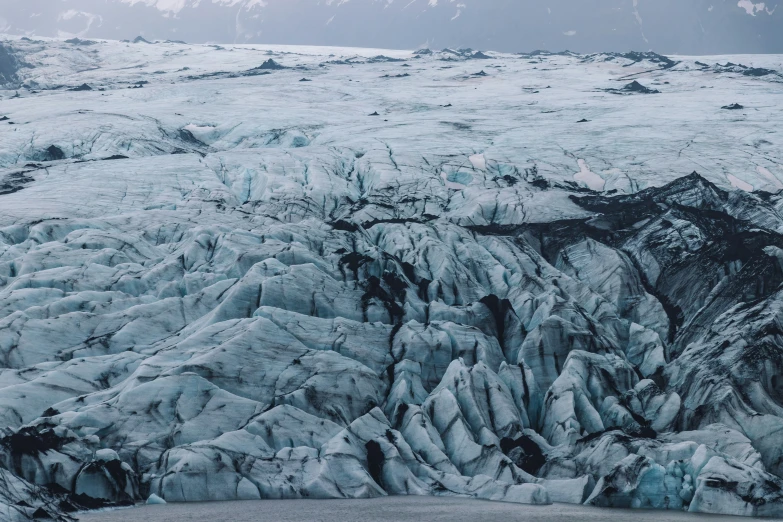 an glacier surrounded by mountains in a foggy sky