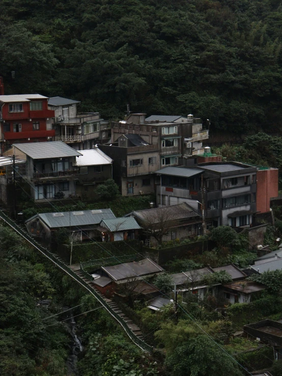 a cluster of buildings sitting on a hill covered with green vegetation