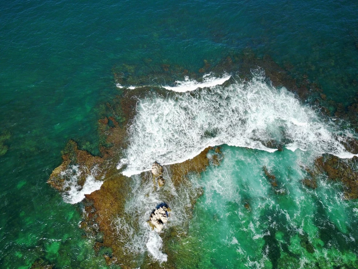 this is an aerial view of an ocean with surfers
