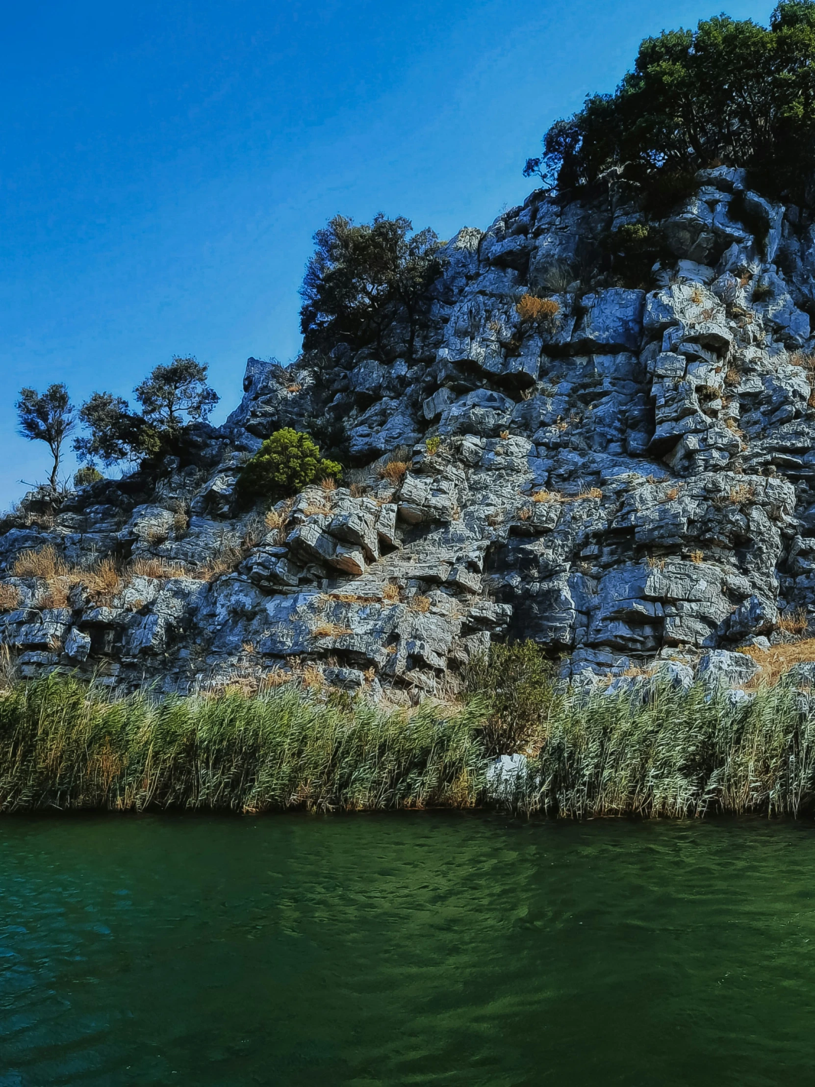 there are lots of tall hills on the side of a lake