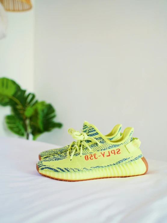 yellow sneakers are displayed on a white surface