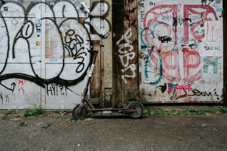 a tricycle parked in front of a graffiti covered wall