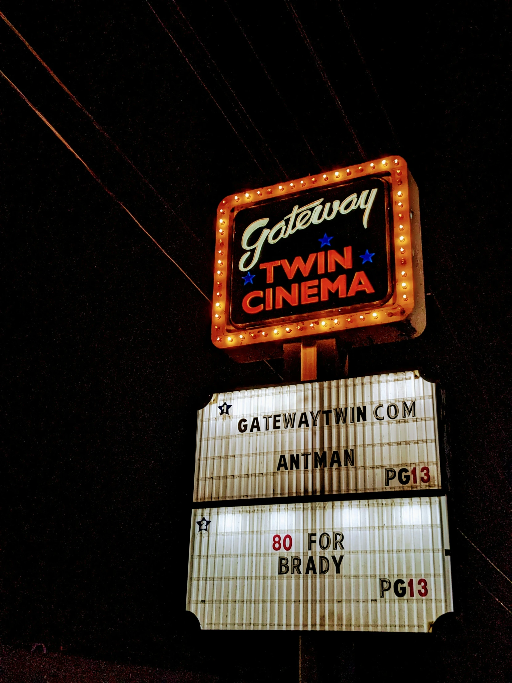 a tall sign is lit up on the top of a building