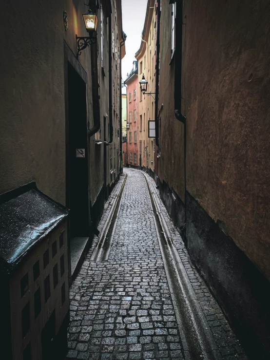 a street in a city has cobblestone floors and a stone road