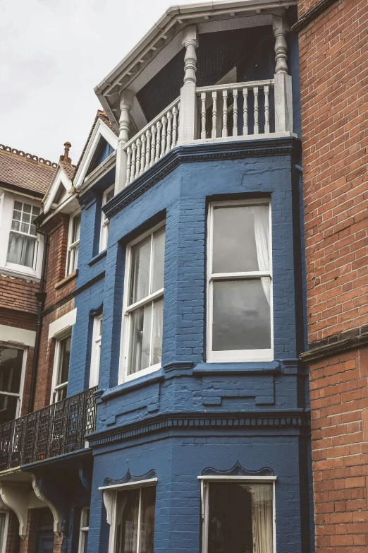 a blue building with white balconies on each level