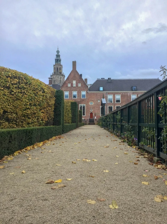 a house is behind the hedges on this path