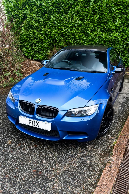 a blue bmw car parked on the side of the road