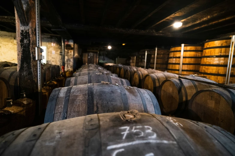 several wine barrels in a cellar at night