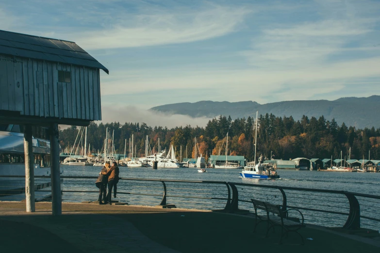 a couple of people standing on top of a pier