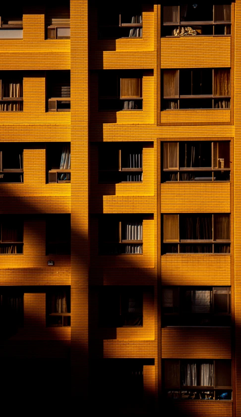 an orange colored building with balconies next to a street