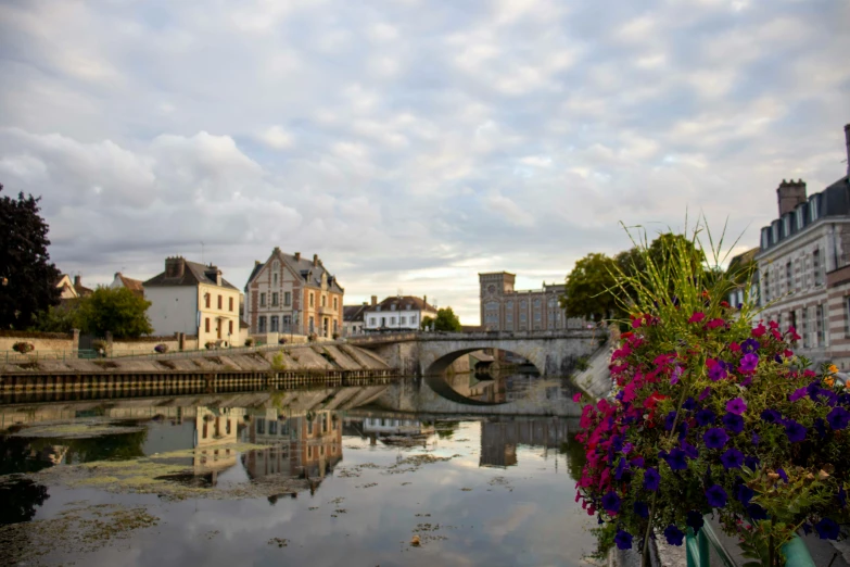 an ornate bridge surrounded by buildings and flower pots