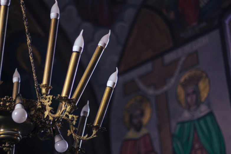 many candles are hanging from the ceiling of a large church