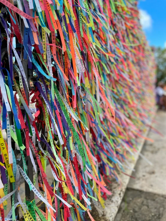 a wall covered in multi colored ribbons and streamers