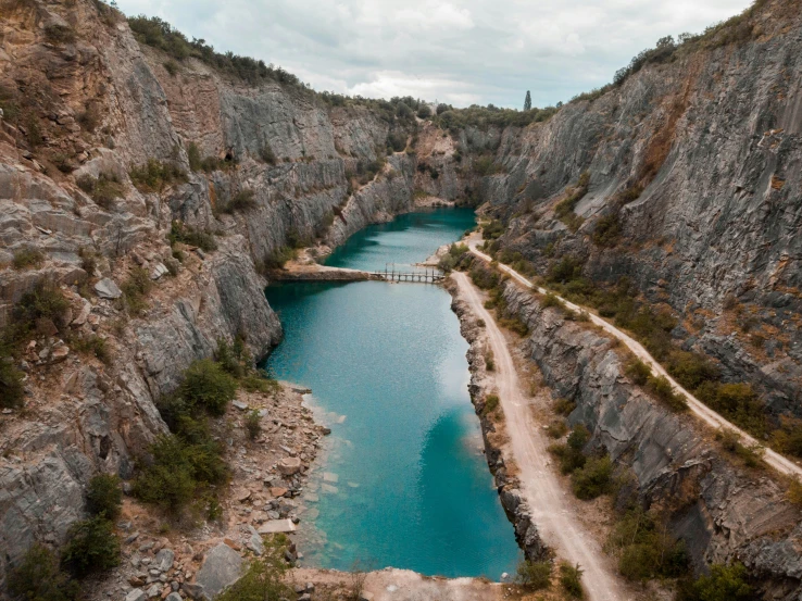 an aerial view of a small bridge between two rivers