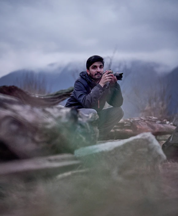 a man that is kneeling down with a camera