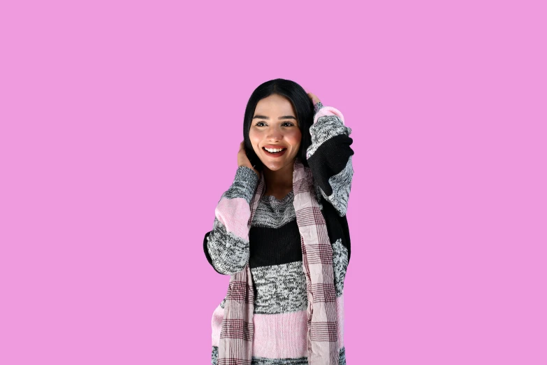 a girl in a pink and black sweater listening on the phone
