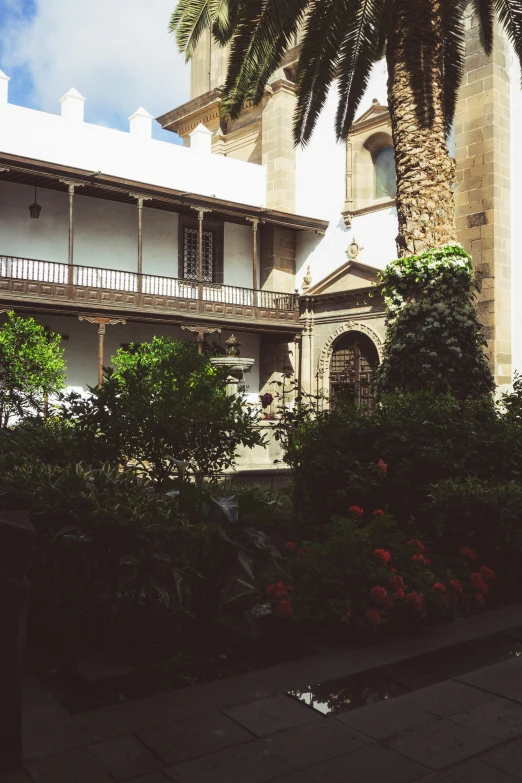 an old house with many balconies and palm trees in front