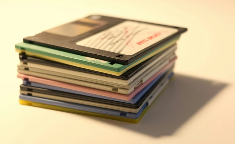 a stack of colorful records sitting on top of a white counter