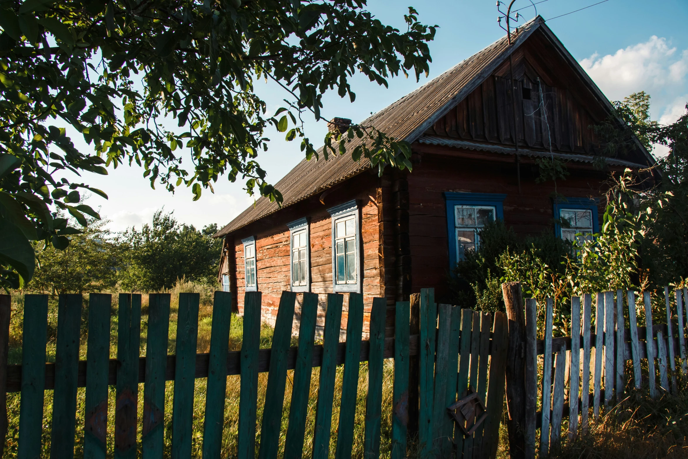 a small home with a wooden fence around it