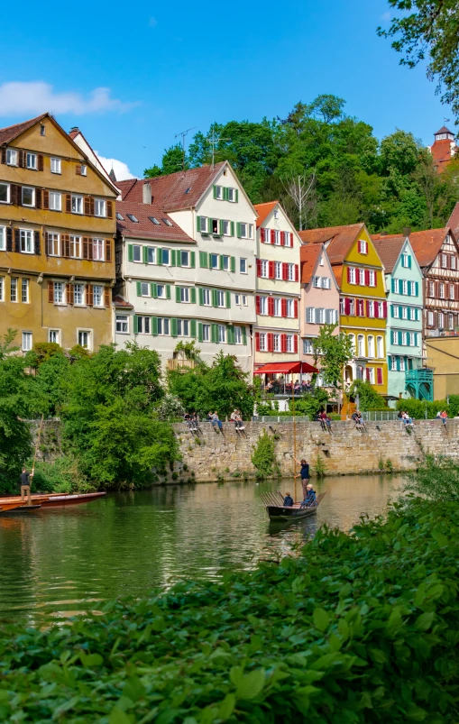 an old building near a small river and canoe on the water