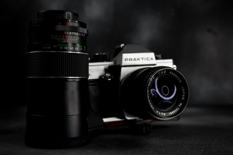 a camera on a dark background next to a lens