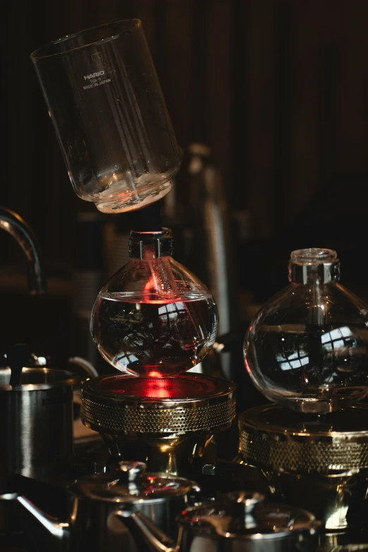 glass bottle with red liquid next to an electric kettle