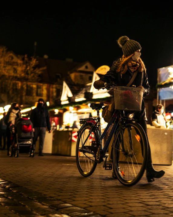 a woman standing on the sidewalk next to a bike