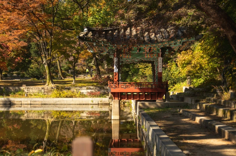 a wooden bridge over a body of water surrounded by trees