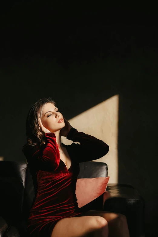 a woman in a red dress sitting in a chair