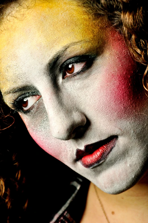 a woman's face has a makeup make up of yellow and red colors