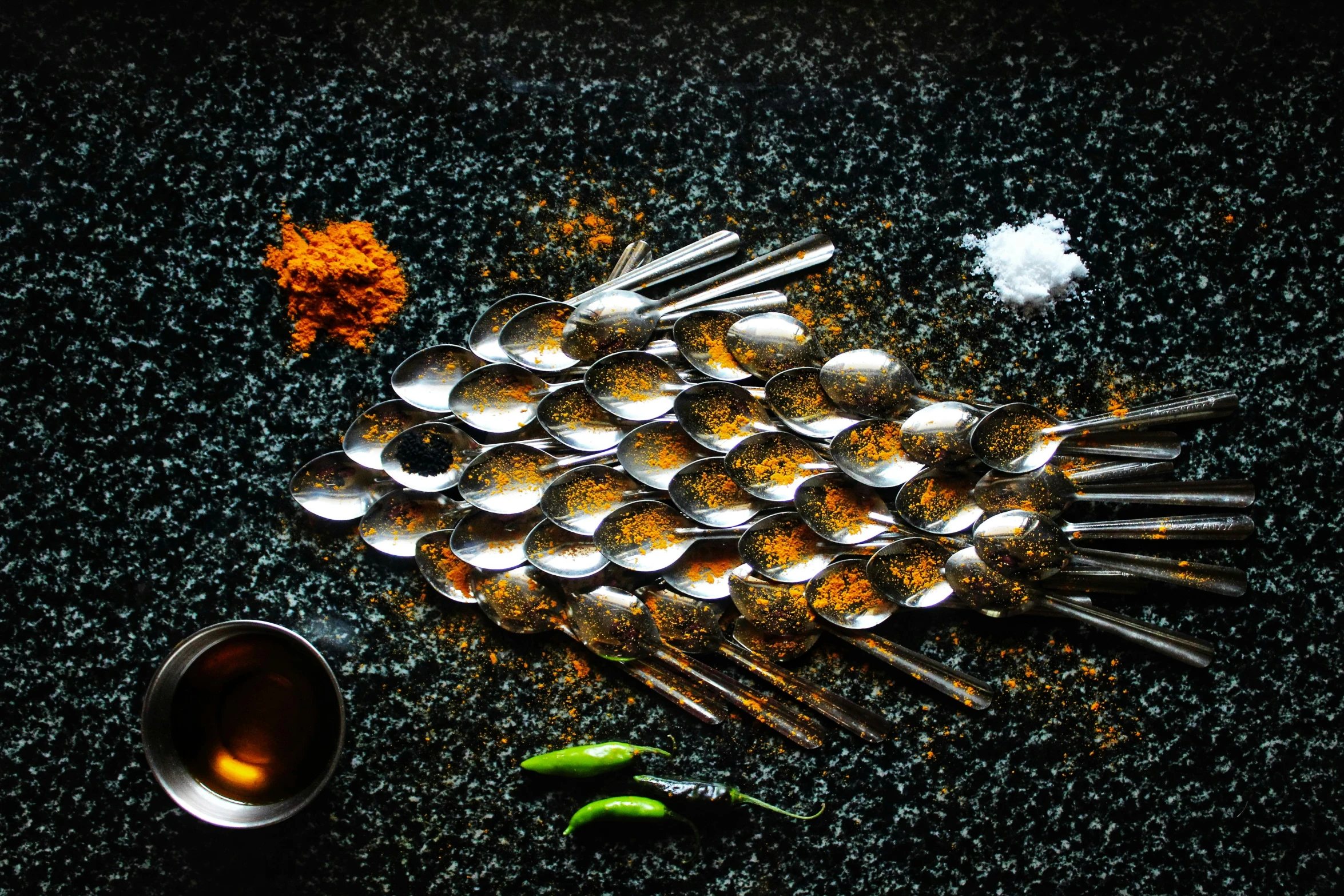 a table topped with measuring spoons filled with spices