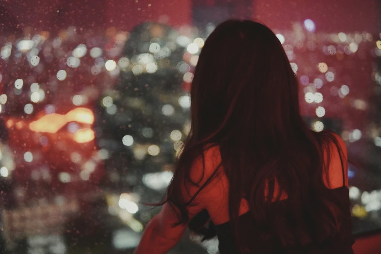 the rear view of a woman looking at the city lights