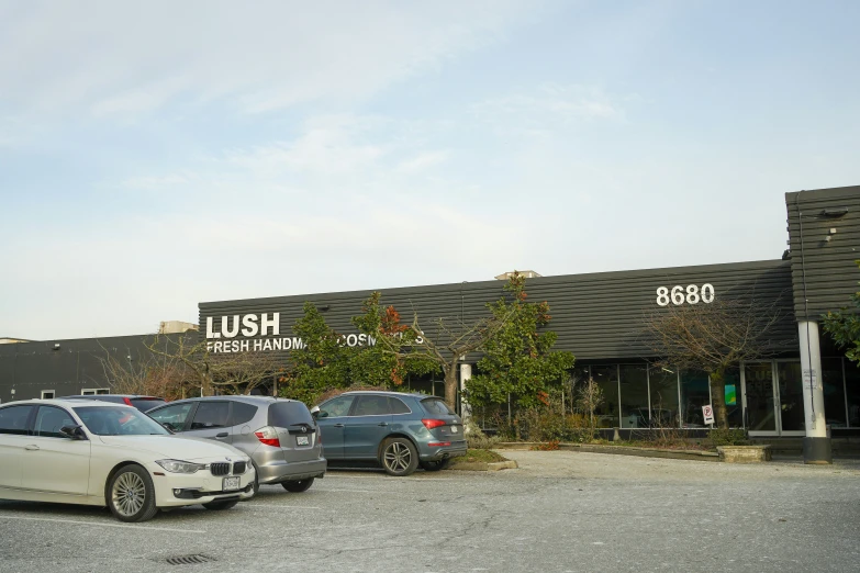 cars parked in front of a building with a sushi sign