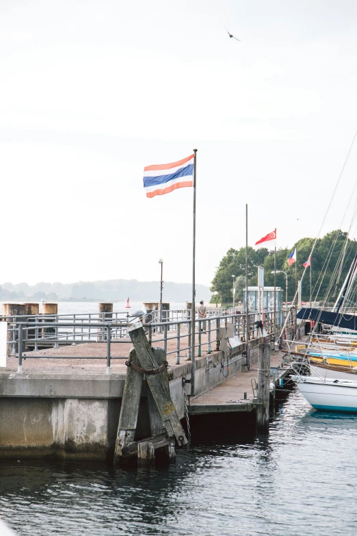 a dock filled with lots of ships and flags