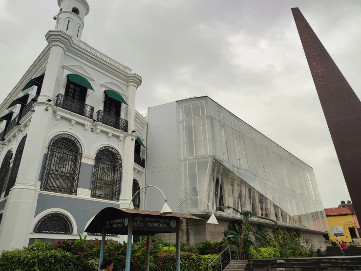 a clock tower sits next to some buildings