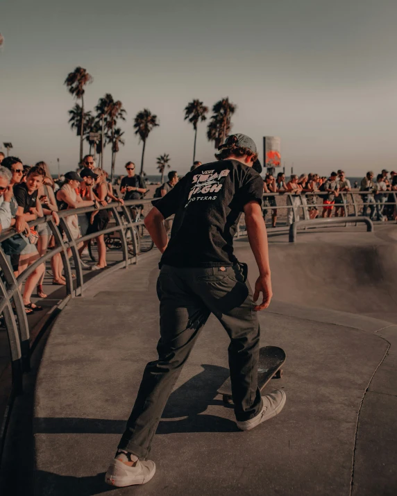 skateboarder riding on a rail with a crowd watching