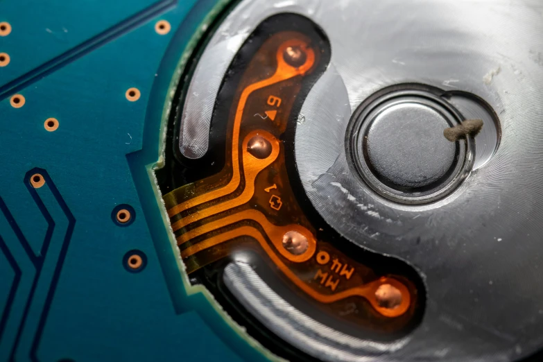 a computer disc containing some orange and yellow wires