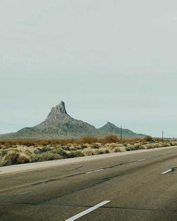 a road with mountains in the distance on an empty highway