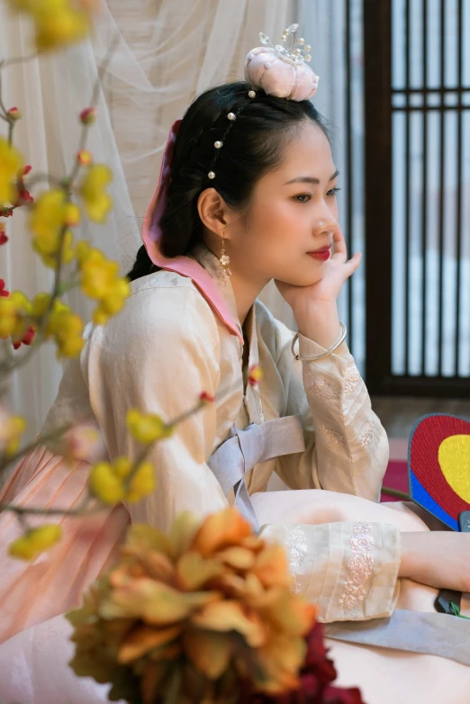 a woman sitting in front of a table with flowers