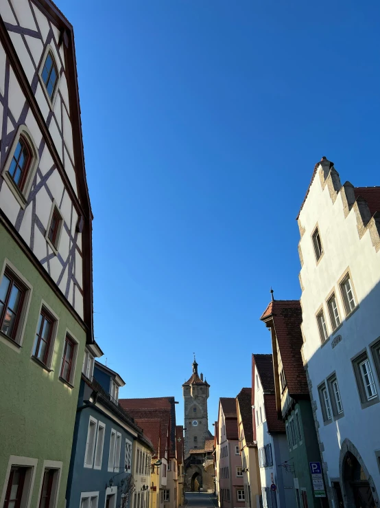 the view down an empty, narrow street from tall buildings