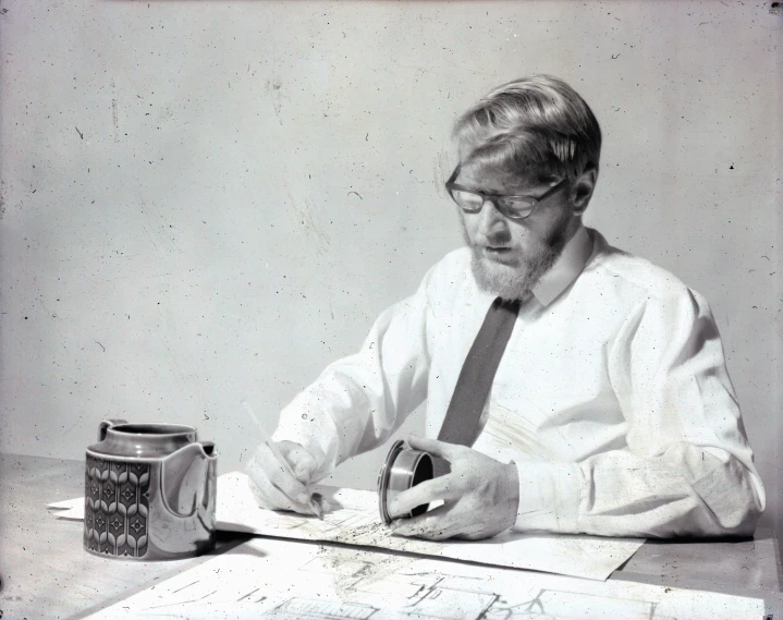 a man sitting at a desk writing on some paper