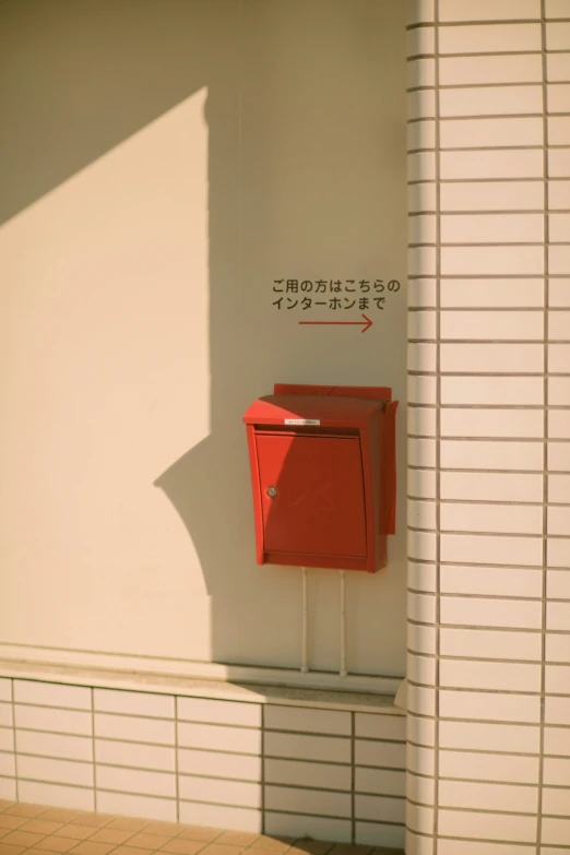 a red box sits on a white wall and is placed near a doorway