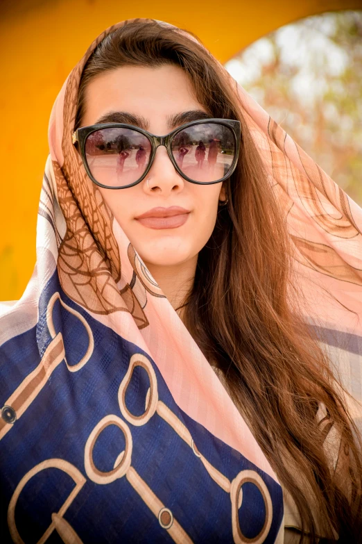 a woman wearing sun glasses and holding an umbrella