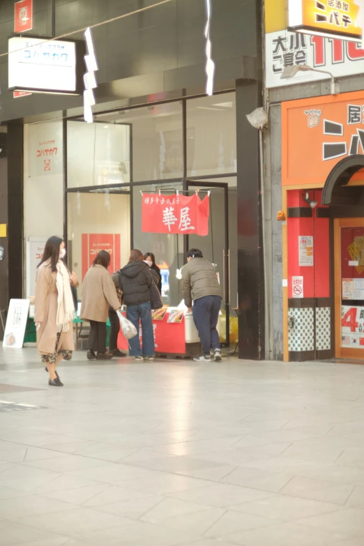 people outside on the street shopping at the food stall