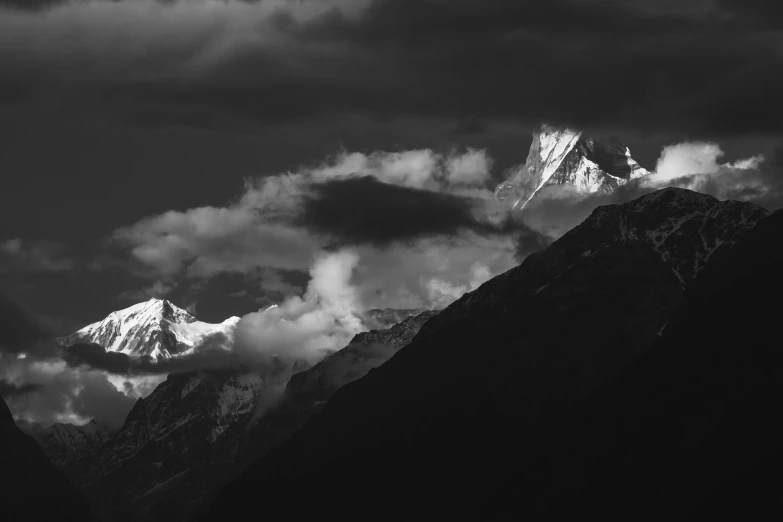 a mountain range is silhouetted against the clouds