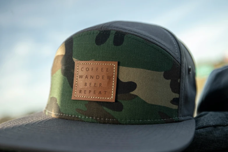 a close up of a camo cap with a leather patch