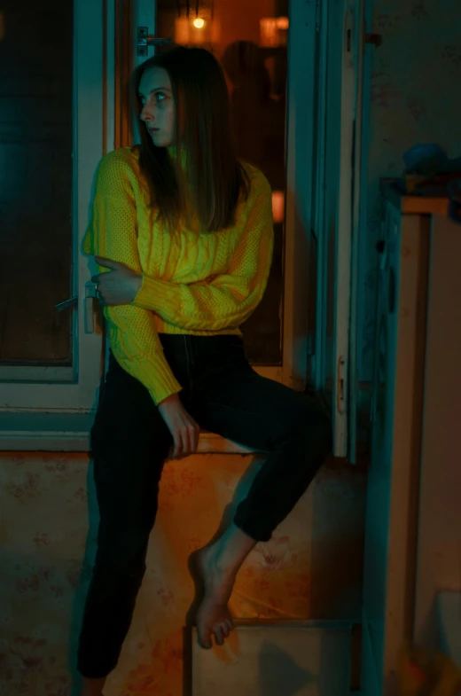 a woman in a yellow top sits on a step