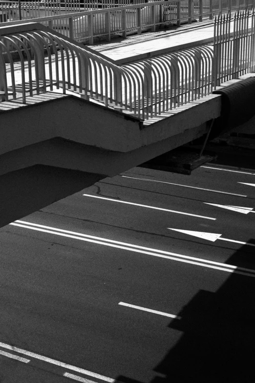 the pedestrian walkway is black and white and has multiple railings