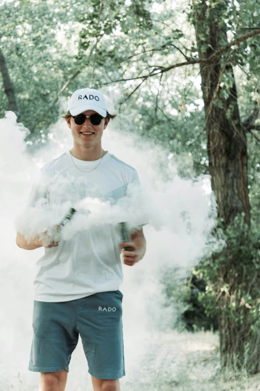 a man wearing a white hat standing near trees