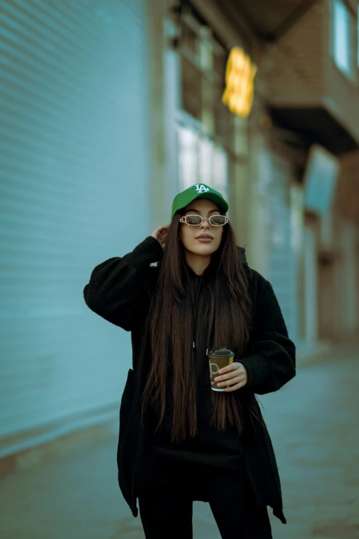 a woman is outside with a green hat on